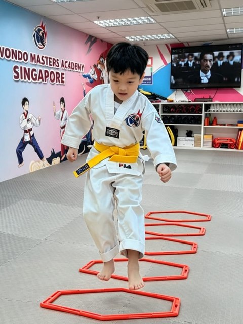 Yellow belt student training footwork through agility rings