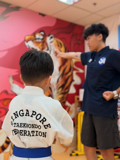 Coach demonstrating technique to a student